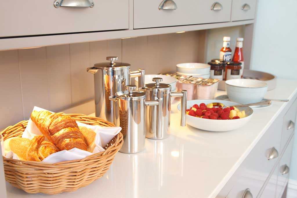The sideboard in the breakfast room laid out with cereals and pastries